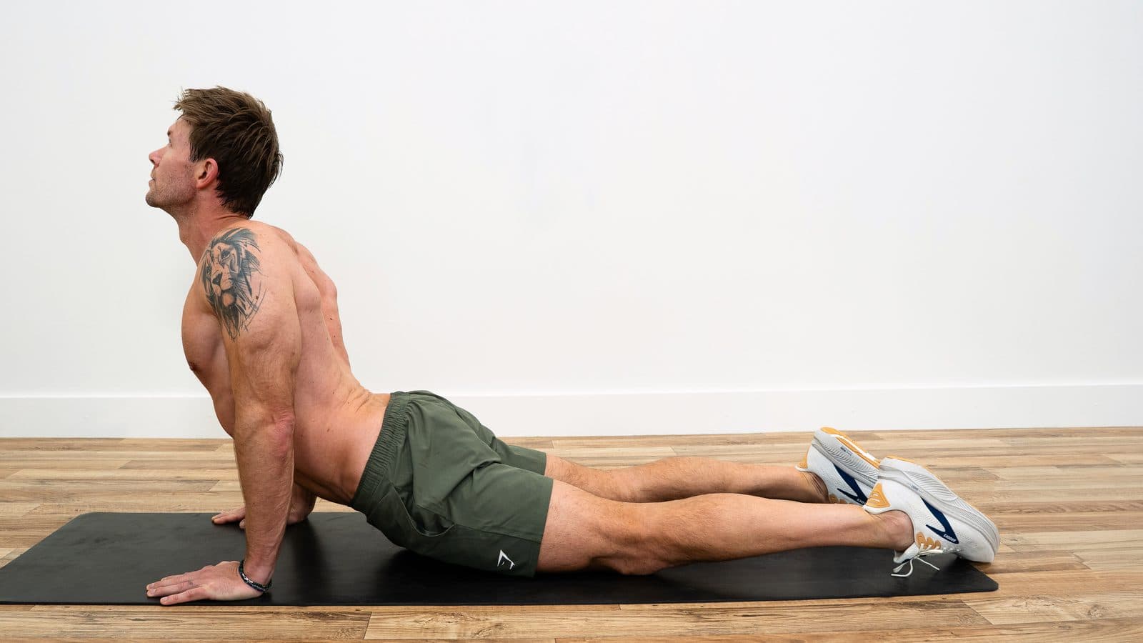 Dan lying face down, pressing up on straight arms with his hips on the floor